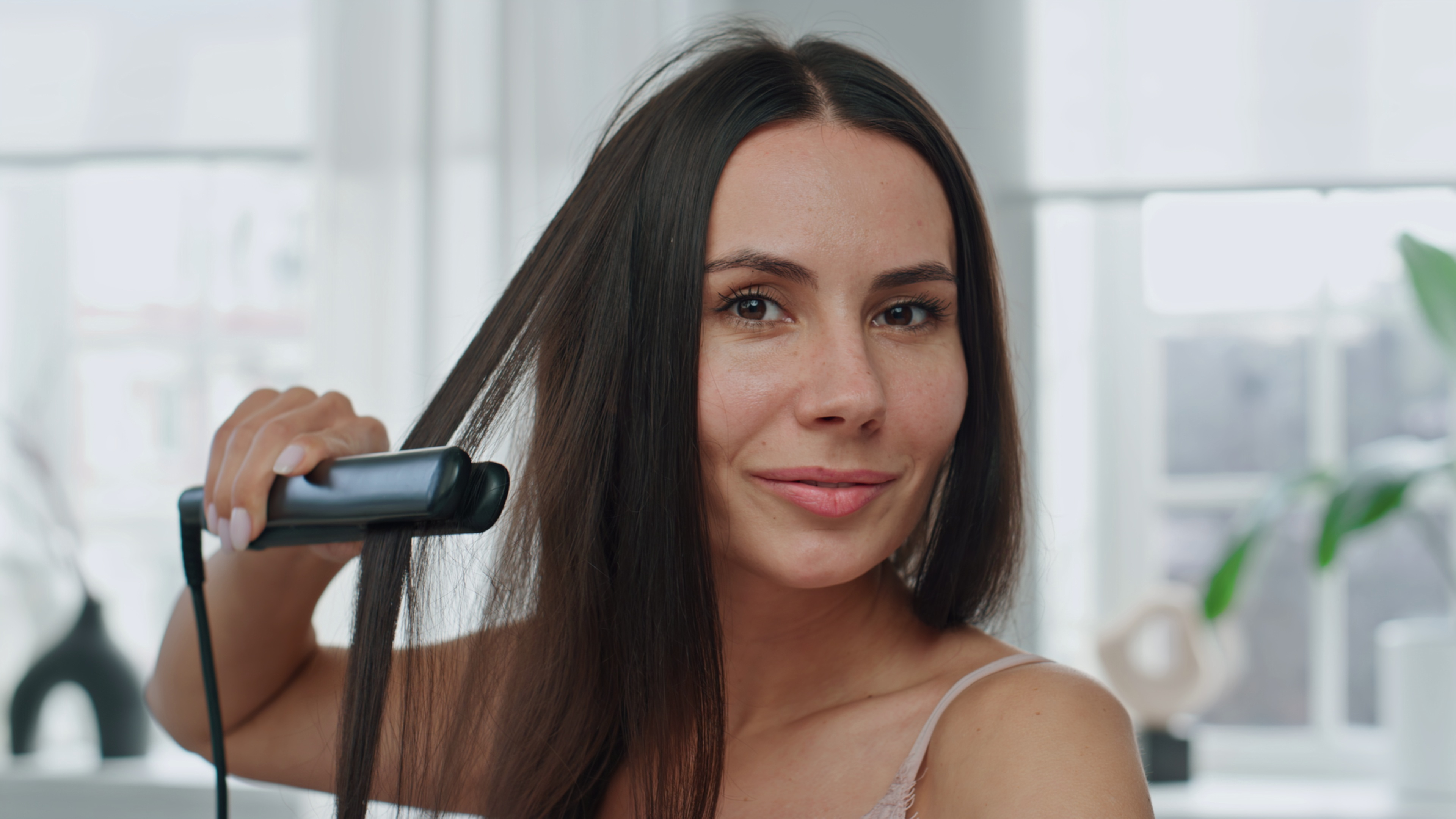 Woman styling hair with a straightener